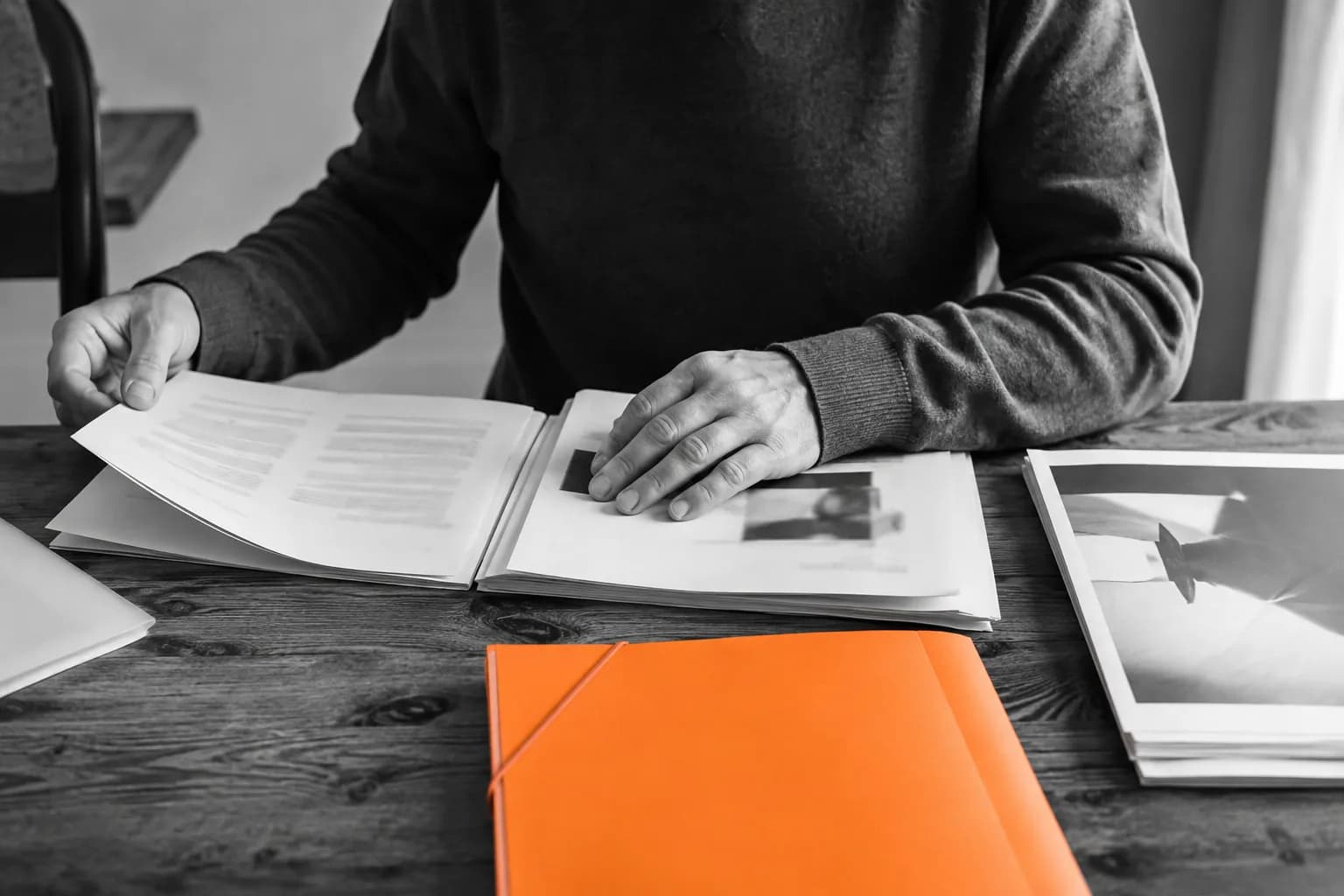Propietario revisando manuales y documentos junto a una carpeta naranja